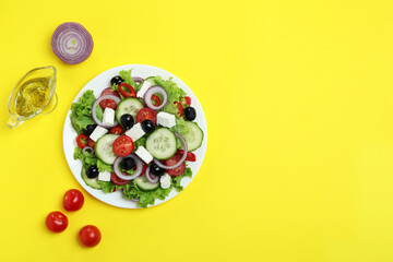 Concept of delicious food with Greek salad on yellow background