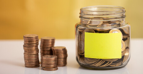 Coin in glass bottle with money stack