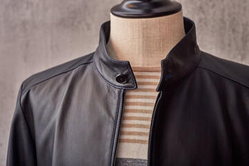 Men's casual black leather jacket on a mannequin collar closeup