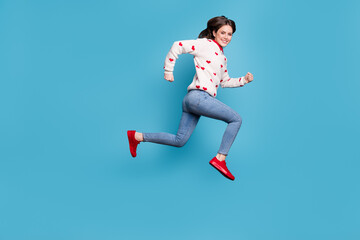 Fototapeta na wymiar Full length photo of sweet young woman dressed hearts print pullover running jumping high isolated blue color background