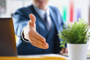 Man in business suit stretching out his hand for handshake closeup