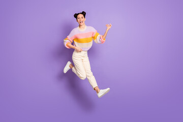 Full length photo of sweet funny young lady dressed striped sweater jumping playing guitar isolated violet color background