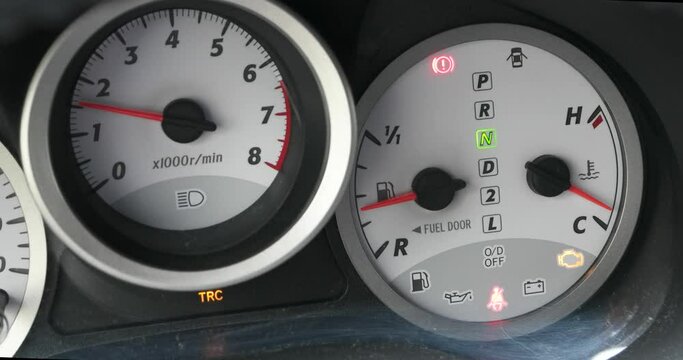 Car gauge tachometer rev counter showing engine revving up and idling