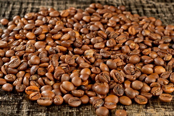 Coffee beans close up on a wooden board. Coffee on a black shabby table.