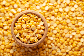 Macro Close-up of  Organic Bengal Gram (Cicer arietinum) or split yellow chana dal in an earthen clay pot (kulhar) on the self background. Top view