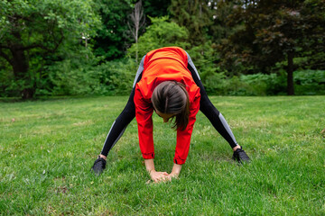 Fototapeta na wymiar young girl stretches in the park