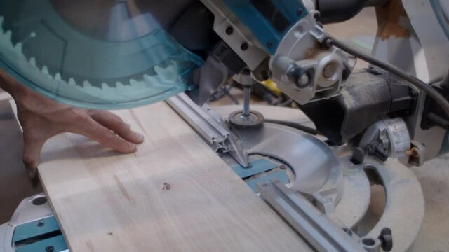 Carpenter's shop.  Woodwork with a miter saw. Professional carpenter at work. 