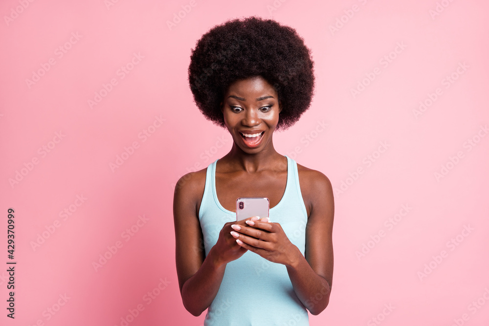 Sticker Photo of trendy happy nice dark skin lady hold look phone like reaction notification isolated on pink color background