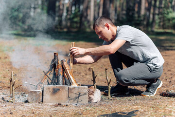 a man lights a fire. family vacation in nature