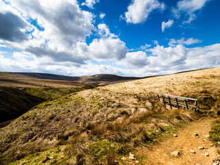 A little wooden footbridge on moorland crosses a stream with Little Whernside mountain in the background. Angram moor. Nidderdale. Yorkshire Dales National Park