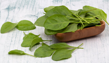 Baby spinach leaves in wooden bowl
