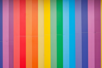Multicolored strips of paper on the wall. Paper with rainbow colors. Interior design.