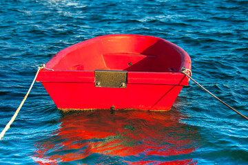 Red Dinghy .Isolated. Copy Space. Small wooden  bright red dingy moored in marina. Stock Image.