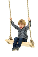 Cute boy sitting on rope swing