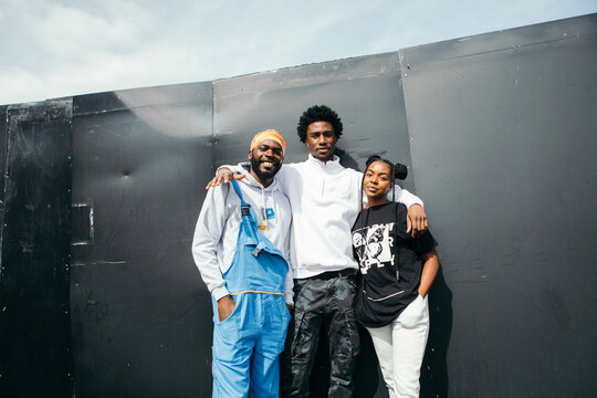 Friends posing together by wall