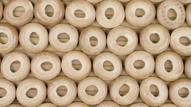 Drying or mini round bagels on wooden background. Top view. Donut snack