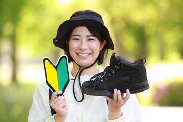 登山靴と初心者マークを持つ女性