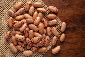 Macro Close-up of Organic White Kidney Beans or Lobia (Phaseolus vulgaris) on Jute mat and wooden top.
