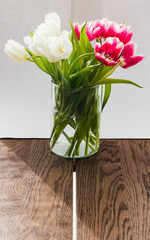 vase with tulips on wooden table