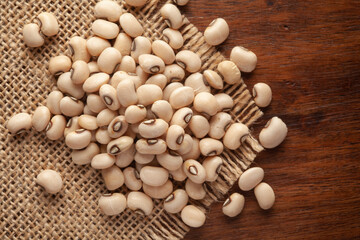 Macro Close-up of Organic Soybean (Glycine max) or Soya bean dal on Jute mat and wooden top.