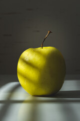 Green apple under the sunshine in front of the window
