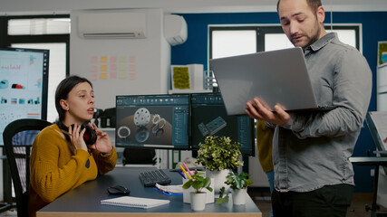 Woman architect engineer taking off headset talking with project manager analysing industrial...