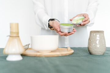 Preparing matcha. Close up of female pouring green tea in a bowl