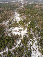 Aerial view of winding river, bridge and forest in Riezupe river nature park in winter day, Latvia. 