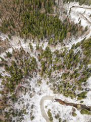 Aerial view of forest, winding road and winding river in Riezupe river nature park in winter day,...