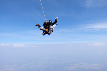 Naklejka na ściany i meble Skydiving. Tandem jump. Man and woman in the sky.