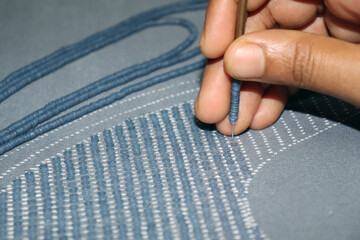 woman shoes design on cloth with hand needle