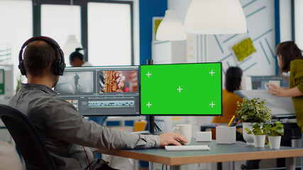Videographer using computer with chroma key, mock up isolated display editing video and audio...