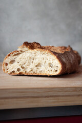 Close up of freshly baked bread  on wooden table. Bread crumbles.