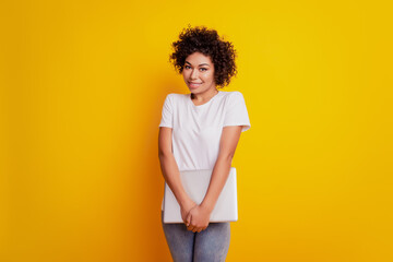 Young smiling african girl shy posing wear white t-shirt on yellow wall