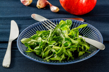 Fresh arugula on a blue plate at lunch 