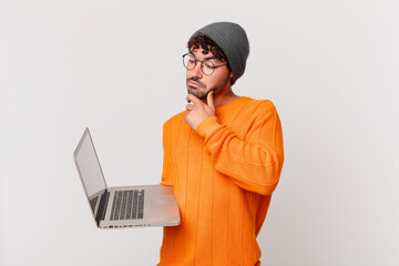 nerd man with computer thinking, feeling doubtful and confused, with different options, wondering...