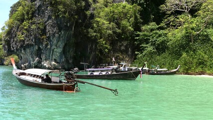 Obraz premium Tourists long tail boat with beautiful nature limestone hill at Andaman Sea, Krabi, Thailand.