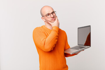 bald man with computer thinking, feeling doubtful and confused, with different options, wondering...