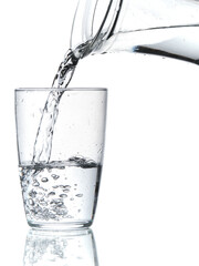 Glass of water being filled. Close up pouring clear water in transparent drinking glass over white background