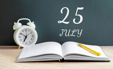 july 25. 25-th day of the month, calendar date.A white alarm clock, an open notebook with blank pages, and a yellow pencil lie on the table.Summer month, day of the year concept