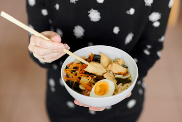 ramen in female hands with chopsticks
