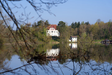 Nature reserve Katzensee (German, translation is cat lake) at springtime morning with forest, houses and reflections. Photo taken April 21st, 2021, Zurich, Switzerland.