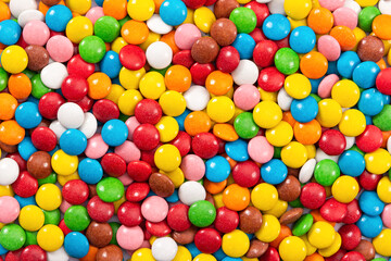 Fototapeta na wymiar Multicolored button-shaped candies as background, close-up.