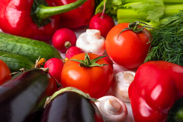 Fresh vegetables background - tomatoes, zucchini, mushrooms, radish, cucumbers, greens