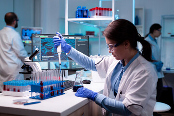 Medical engineer scientist uses micropipette, pipette taking sample from test tube. Woman research...