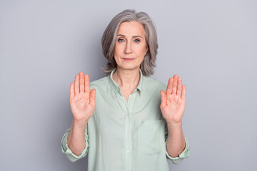 Photo of serious strict displeased mature woman showing no stop gesture restriction isolated on...