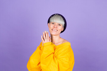 Stylish european woman on purple background happy sweet smile hands together