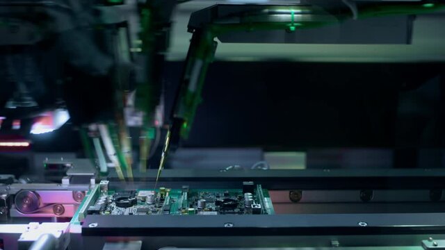 Production of electronic circuit boards. Machine for automatic installation of components on an electronic board. Manufacturing of microcircuits and microprocessors. The transistors are installed.