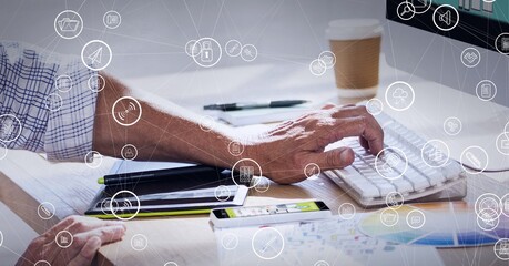 Composition of network of connections with digital icons over man typing on computer keyboard