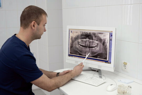 The dentist shows a picture of the patient in the computer